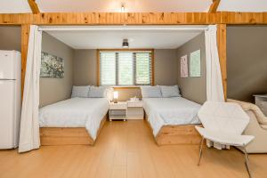 1 dormitorio con 2 camas y nevera en Muskoka Lakeshore Cottage Bliss, en Gravenhurst