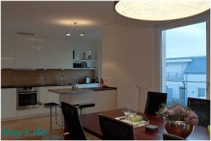 a kitchen and dining room with a table with chairs at Ney3 in Norderney +3 photos