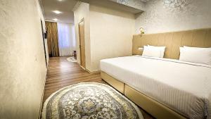a bedroom with a bed and a rug in a room at Hotel Bankir Khiva in Khiva