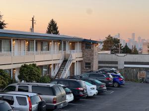 a parking lot with cars parked in front of a building at Marco Polo Motel in Seattle