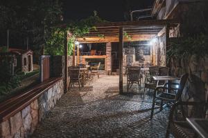 an outdoor patio with tables and chairs at night at Penzion Hurikán 63 in Havlíčkŭv Brod
