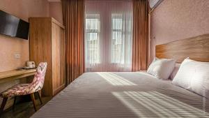 a bedroom with a bed and a chair and a window at Hotel Bankir Khiva in Khiva