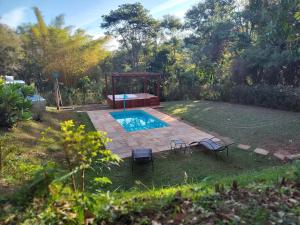 um quintal com uma piscina e um gazebo em Govinda Moeda Pousada em Moeda