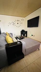 Schlafzimmer mit einem Bett und einem Flachbild-TV in der Unterkunft Senderos Apartment, Self Check- in, Airport SJO 5 MIN in Río Segundo