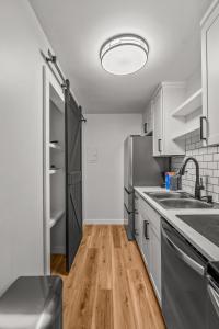 uma cozinha com electrodomésticos em aço inoxidável e piso em madeira em Cozy Condo Near Downtown! em Louisville