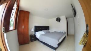 a small bedroom with a bed and a window at SAN GIL-Hotel Resort Campestre Puerta Del Sol in La Cabrera