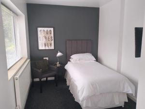 a bedroom with a white bed and a chair at Wentvale in Knottingly