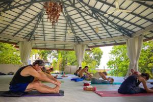 拜縣的住宿－Re Connect Pai - Keys Resort，一群人在伞下做瑜伽