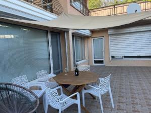 a wooden table and chairs on a patio at Cosy Breeze Apartment in Varna City