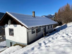 ein weißes Haus mit Schnee auf dem Dach in der Unterkunft Nocky Mountains Lodge in Radenthein