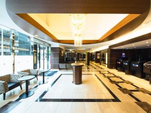 a lobby with tables and chairs and a chandelier at APA Hotel Osaka Tanimachi Yonchome-Ekimae in Osaka