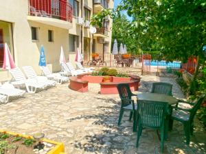 a patio with chairs and tables and chairs and umbrellas at Guest House Granat in Sunny Beach