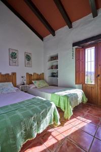 - une chambre avec 2 lits et une fenêtre dans l'établissement Villa Botero, à Constantina