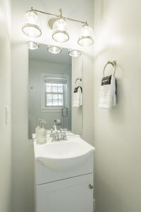 Baño blanco con lavabo y espejo en 06 The Mollino Room - A PMI Scenic City Vacation Rental, en Chattanooga