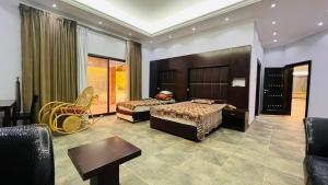 1 dormitorio con 2 camas, mesa y sillas en Greenland Farm - Dubai Margham, en Dubái