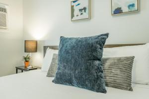 - une chambre avec un lit blanc et un oreiller gris dans l'établissement 09 The Breuer Room - A PMI Scenic City Vacation Rental, à Chattanooga