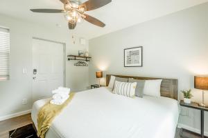 a bedroom with a white bed and a ceiling fan at 08 The Evans Room - A PMI Scenic City Vacation Rental in Chattanooga