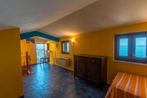 1 dormitorio con paredes amarillas, 1 cama y ventana en MiraMare Residence Cefalú, en Cefalú