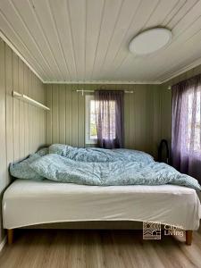1 dormitorio con 1 cama grande con sábanas azules en Close to nature cabin, sauna, Øyeren view, Oslo vicinity en Hektner
