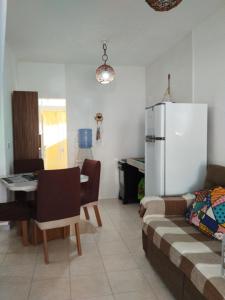 uma sala de estar com um sofá, uma mesa e um frigorífico em Apto Aconchegante na Praia Coroa Vermelha em Santa Cruz Cabrália