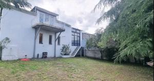 a large white house with a yard in front of it at Дом Лашо всё хорошо in Tbilisi City