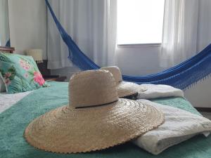 a straw hat sitting on top of a bed at Recanto Maravista apto Frente Mar 2 quartos in Vila Velha