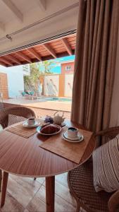 佛羅安那波里的住宿－Casa com piscina climatizada em frente à Praia do Santinho，一张木桌,上面放着两盘食物