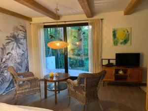 a living room with a table and chairs and a tv at La Bohème in Groß Köris