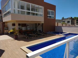 a house with a swimming pool next to a building at Vista mar no ultimo andar! in Ilhéus