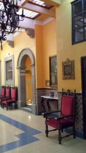 a waiting room with red chairs and a table at Hotel Posada Santa Fe in Guanajuato