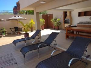 a patio with chairs and a table and a piano at Vista mar no ultimo andar! in Ilhéus