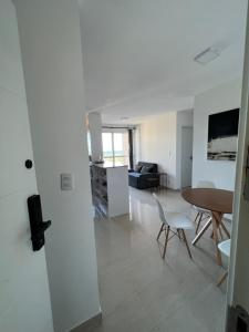 a white living room with a table and chairs at Vista mar no ultimo andar! in Ilhéus