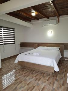 1 dormitorio con 1 cama con sábanas blancas y ventana en Terramar Hoteles en Crucita
