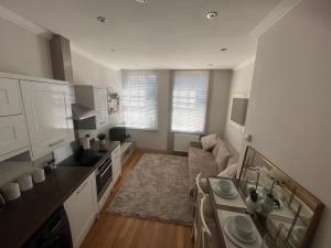 cocina y sala de estar con sofá y mesa en Central private 1 bed flat, en Reading