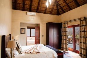 a bedroom with a bed and a large window at Zebula Lodge 118 in Mabula