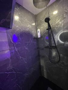 La salle de bains est pourvue d'une douche avec une lumière bleue. dans l'établissement Charmant studio - Vue panoramique lac, à Meillerie