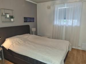 - une chambre avec un grand lit et une fenêtre dans l'établissement Cosy nordic apartment, à Tromsø