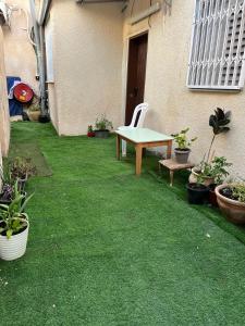 a small yard with a table and some plants at Simply Elegant in Tel Aviv