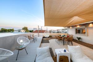 a patio with a couch and tables on a roof at El Cielo Where Luxury meets the sky in Kalamata
