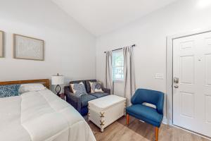 een slaapkamer met een bed en een blauwe stoel bij Town of Rehoboth Beach - 99 Sussex St Unit #2 in Rehoboth Beach