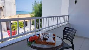 Hotel Pousada Oasis في كوندي: طاولة وكرسي على شرفة مطلة على المحيط