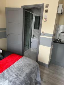 a bedroom with a bed and a bathroom with a sink at Rockford Villa in Perivale