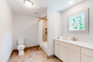 La salle de bains blanche est pourvue de toilettes et d'un lavabo. dans l'établissement Town of Rehoboth Beach - 99 Sussex St Unit #6, à Rehoboth Beach