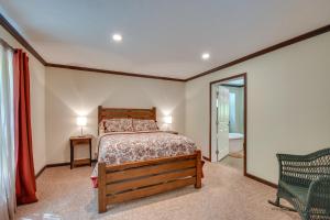 ein Schlafzimmer mit einem Bett, einem Stuhl und einem Spiegel in der Unterkunft Woodsy Hayesville Home on Jackrabbit Trail! in Hayesville