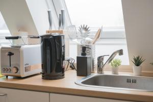 a kitchen counter with a coffee maker and a sink at home2stay Apartments für Monteure in Wendlingen Kitchen,Wifi,Smart TV NEW in Wendlingen am Neckar +60 photos