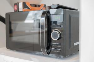 a microwave oven sitting on top of a counter at home2stay Apartments für Monteure in Wendlingen Kitchen,Wifi,Smart TV NEW in Wendlingen am Neckar