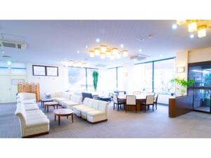 Ashinomaki Prince Hotel - Vacation STAY 55341v في أيزواكاماتسو: لوبي فيه كنب ابيض وطاولة وكراسي