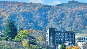 een gebouw voor een berg met bomen bij Ashinomaki Prince Hotel - Vacation STAY 55341v in Aizuwakamatsu