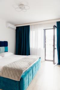 een slaapkamer met een groot bed en blauwe gordijnen bij The blue Norwegian house in Boekarest