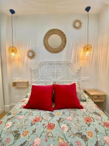 Un dormitorio con una cama con dos almohadas rojas. en A Michelena de Pedra, en Pontevedra